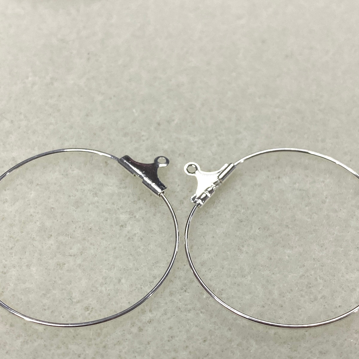 Silver hoop earrings on a light gray background