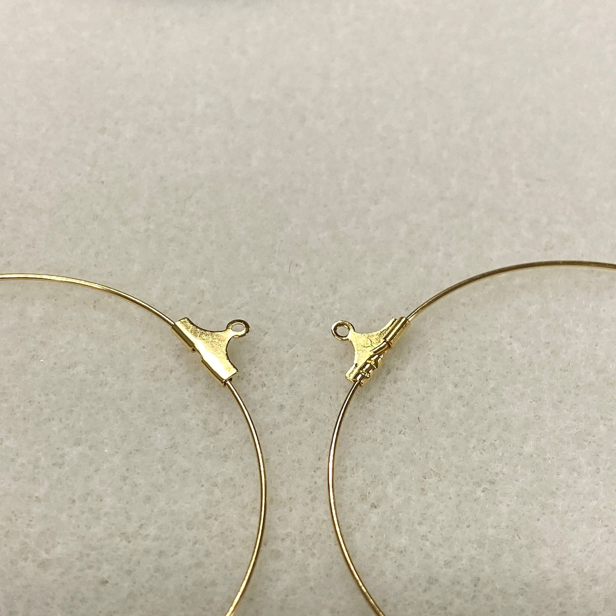 Gold hoop earrings on a light gray background