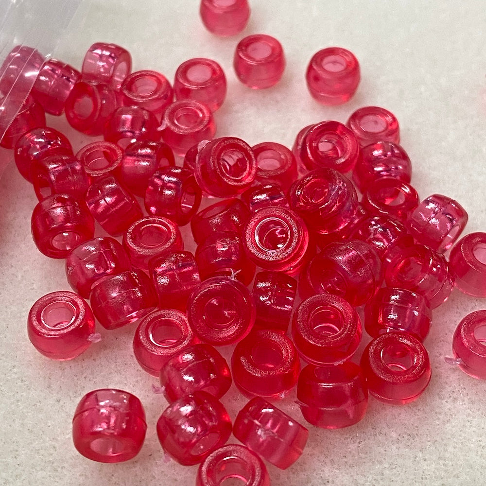 dark rose pink plastic beads on a white background