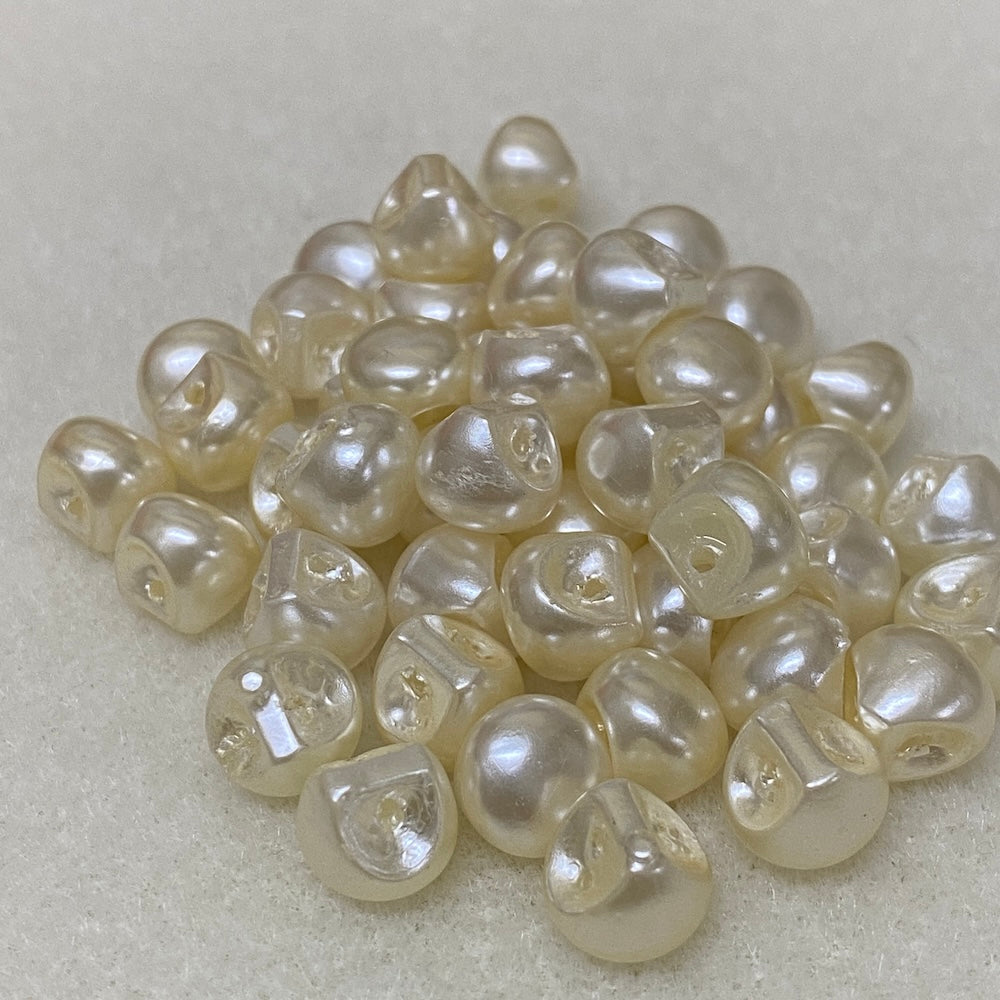 Collection of white pearl buttons on a light gray background