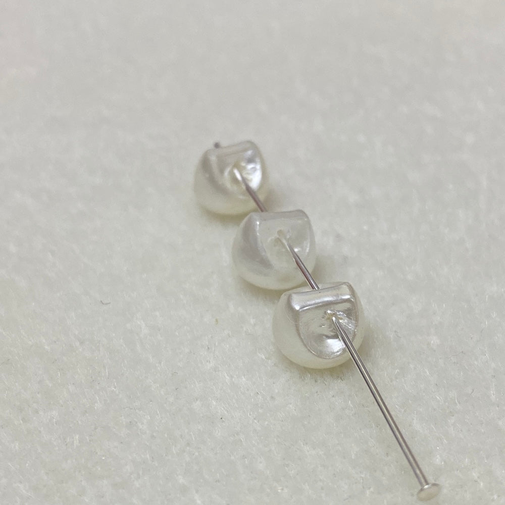 Collection of white pearl buttons on a light gray background