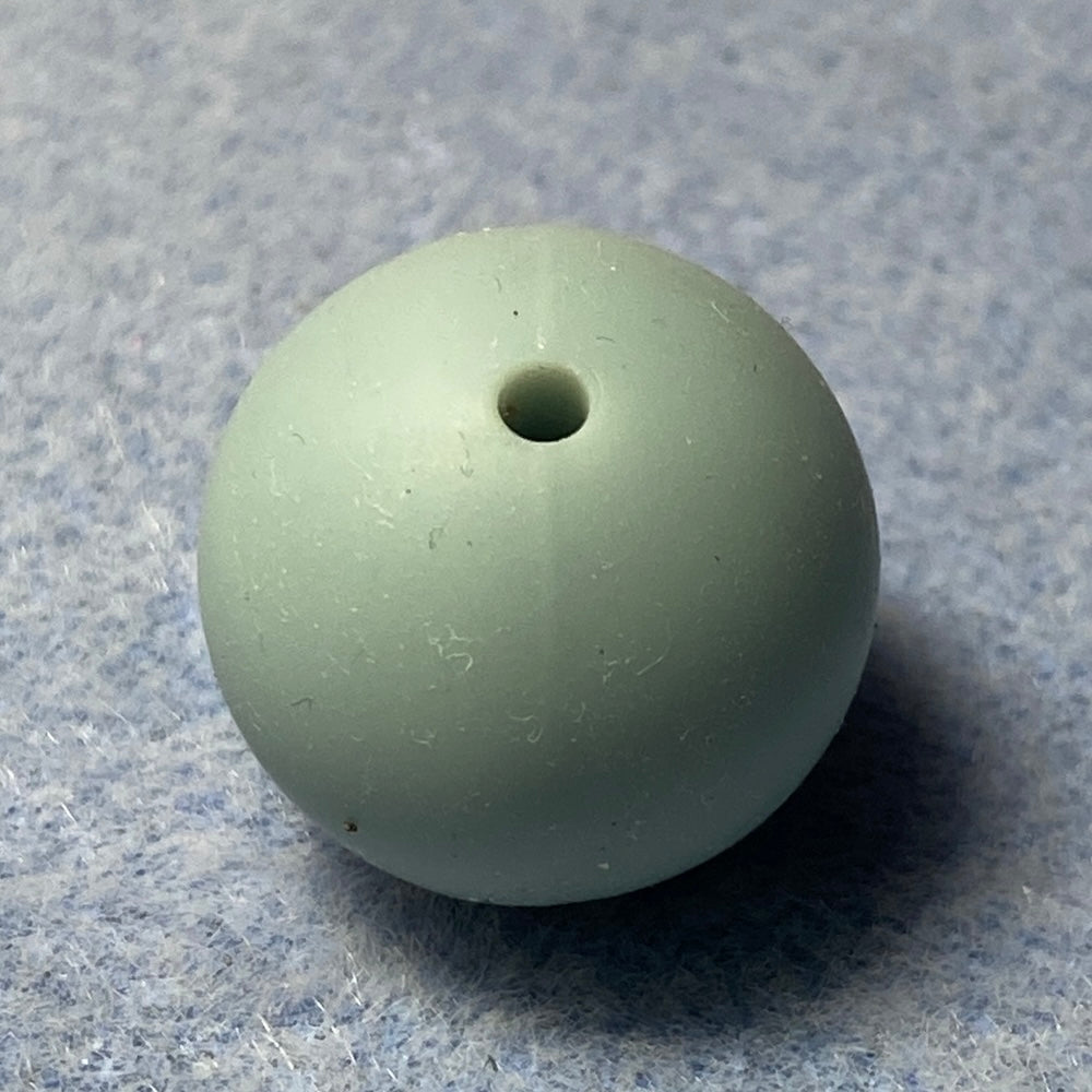 light blue silicone bead on a textured gray background