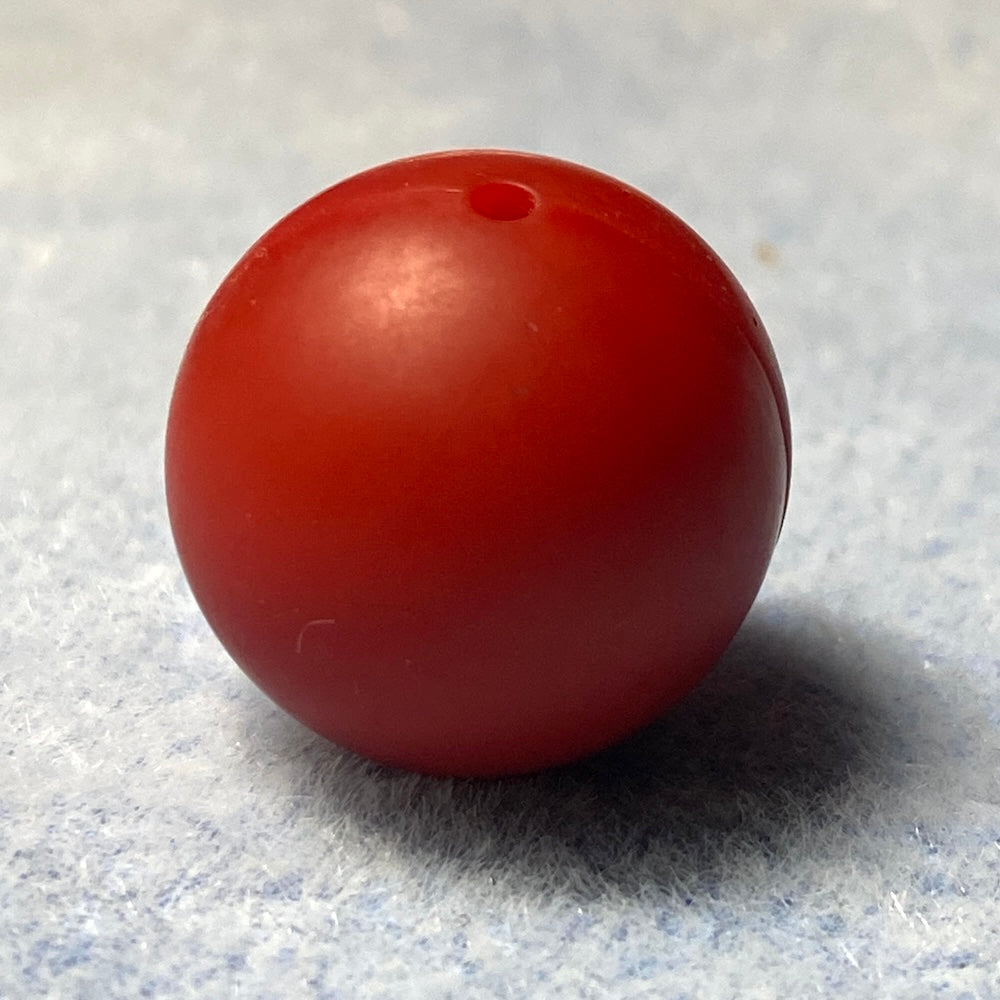 red silicone bead on a textured gray background