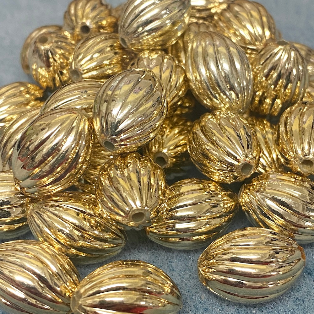 Gold beads with textured surface on a gray background