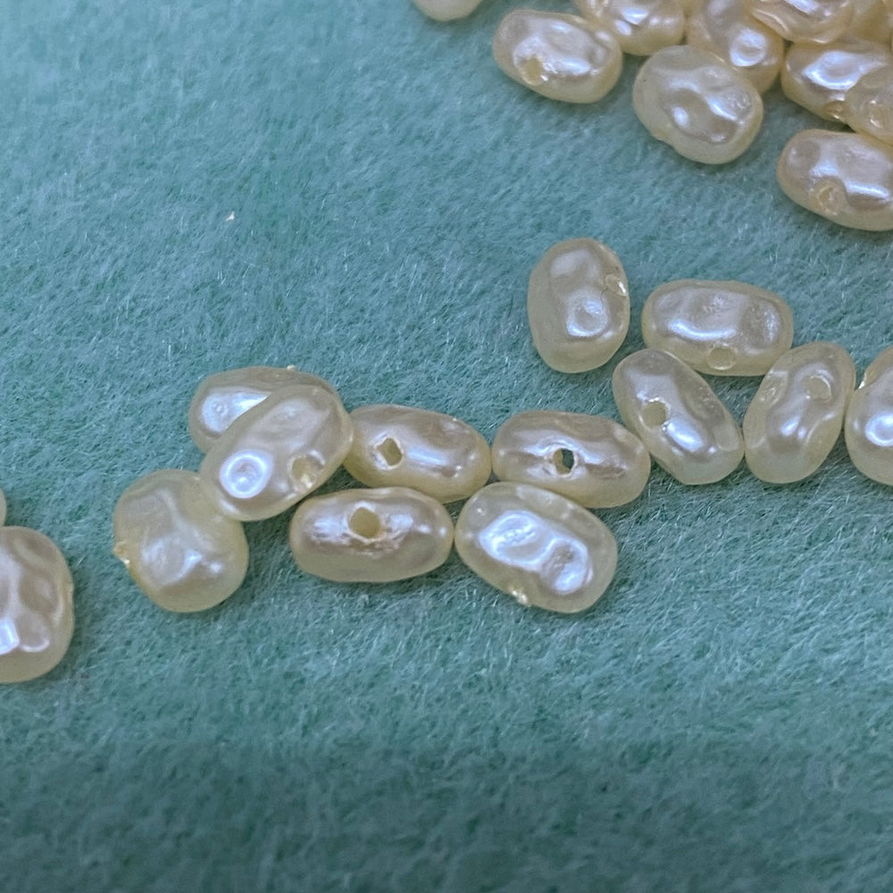 Flat pearls in cream on a grey textured background