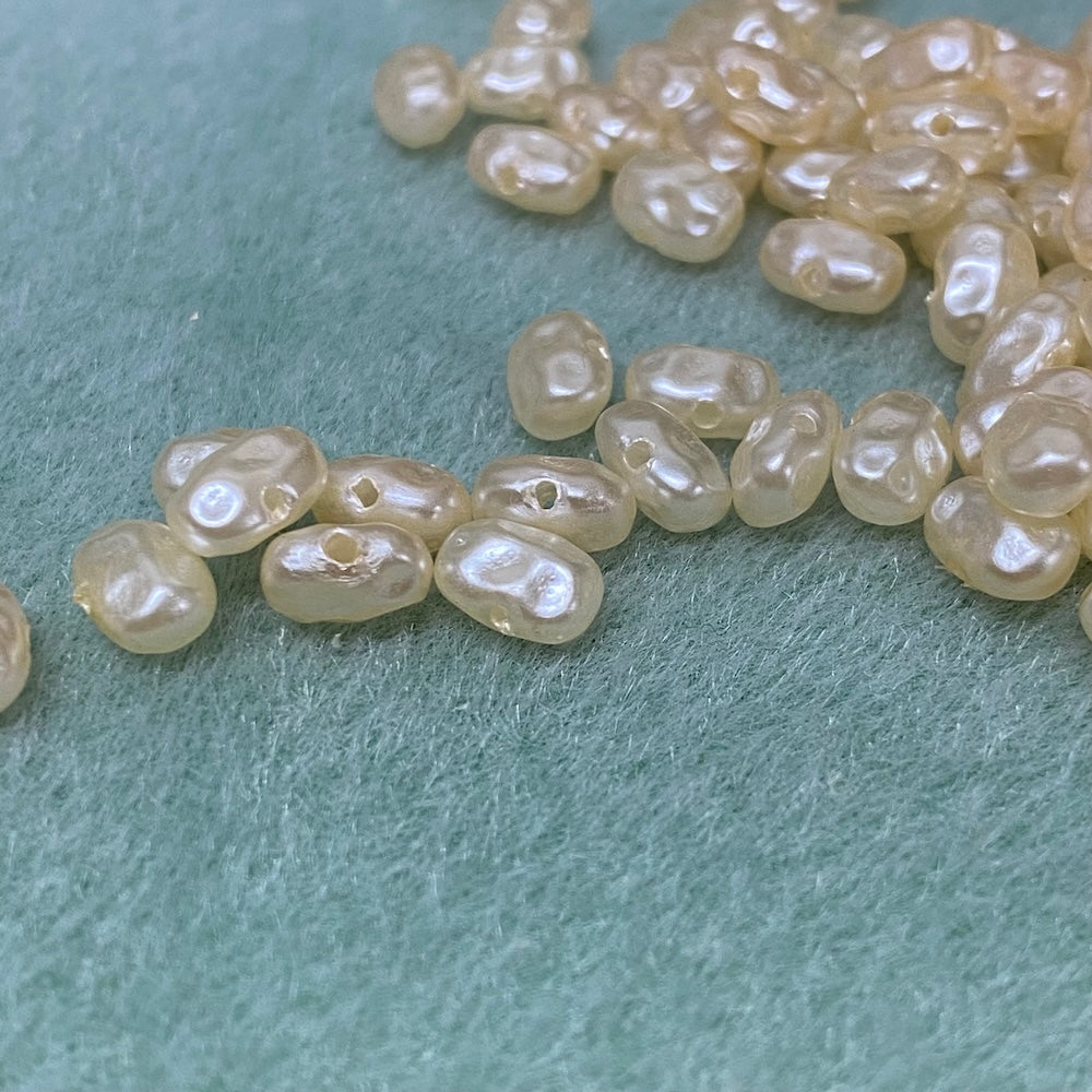 Flat pearls in cream on a grey textured background