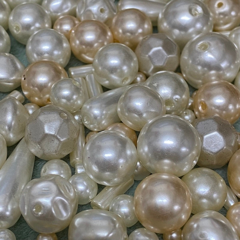 an assortment of different sized and color acrylic plastic vintage pearl beads