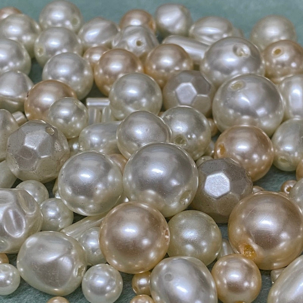an assortment of different sized and color acrylic plastic vintage pearl beads