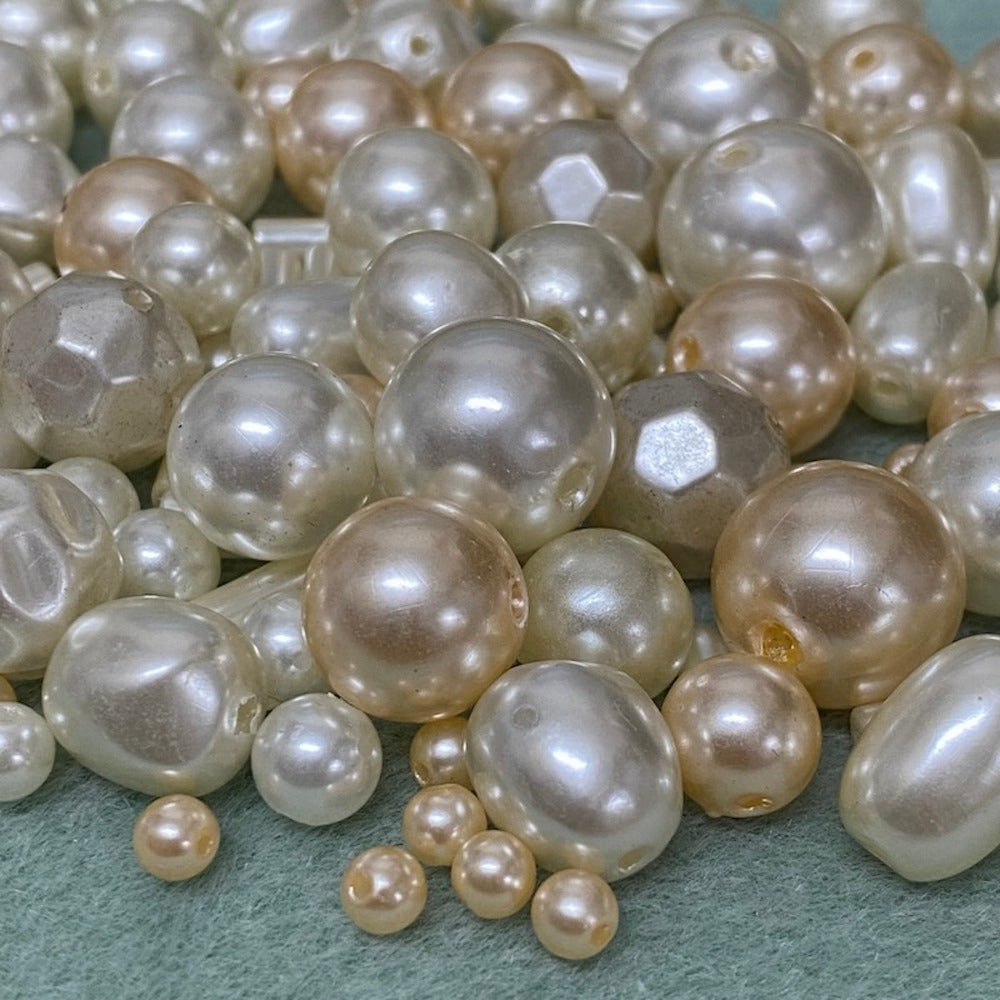 an assortment of different sized and color acrylic plastic vintage pearl beads