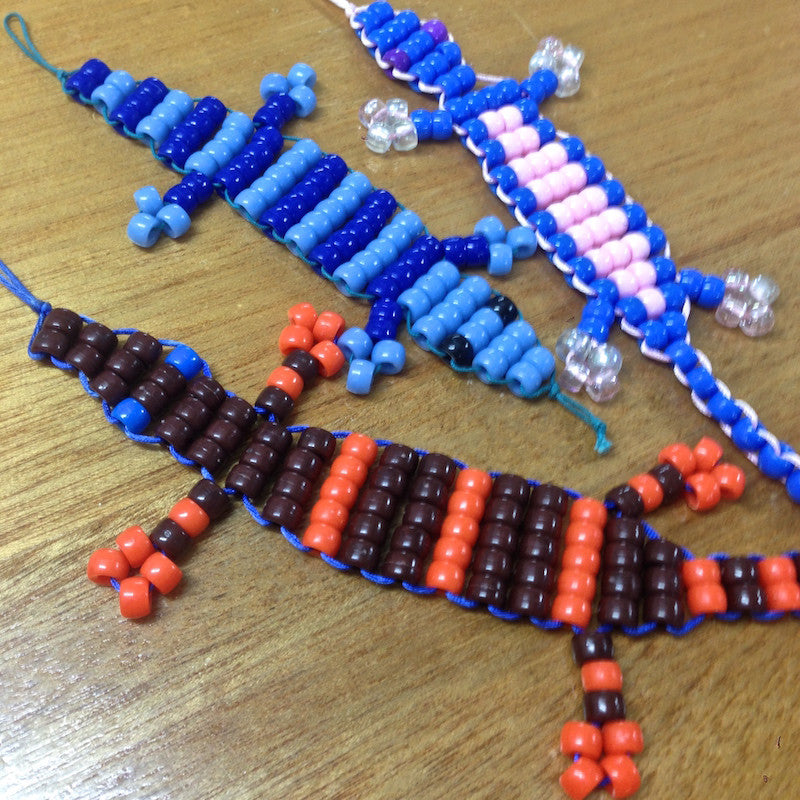 lizard beaded toys made at Bead Shack workshops in variety of colours on a wood surface