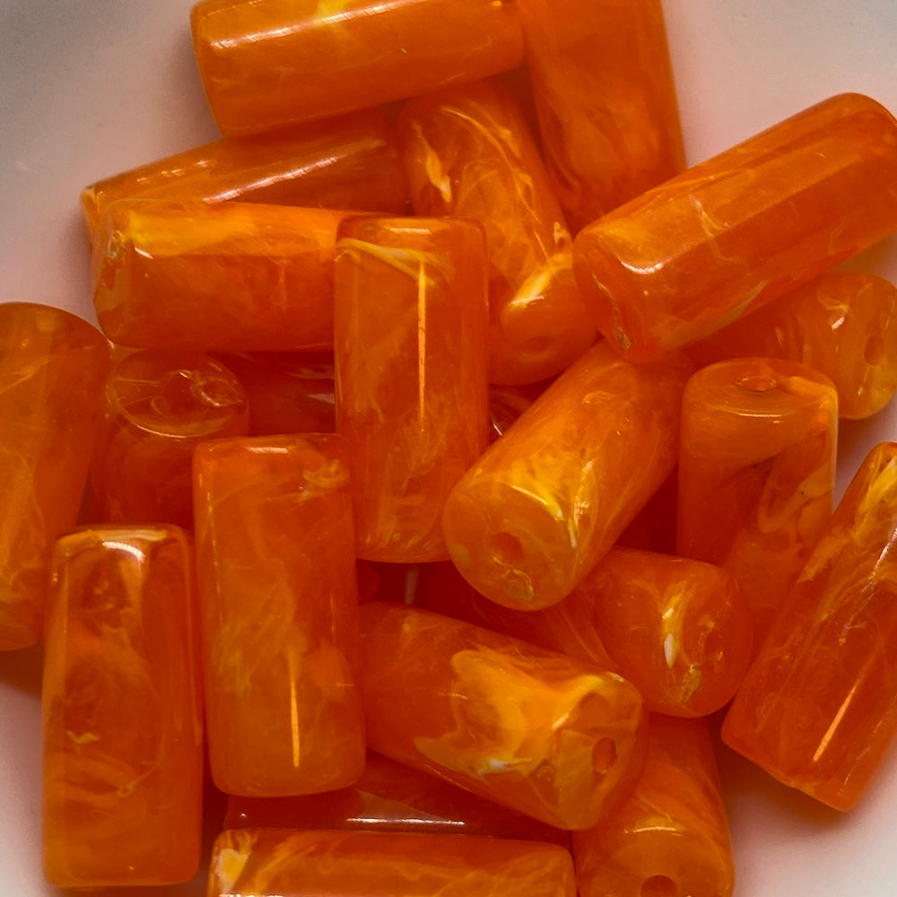 A collection of vibrant, opaque and translucent tube beads with a vintage marbled effect.