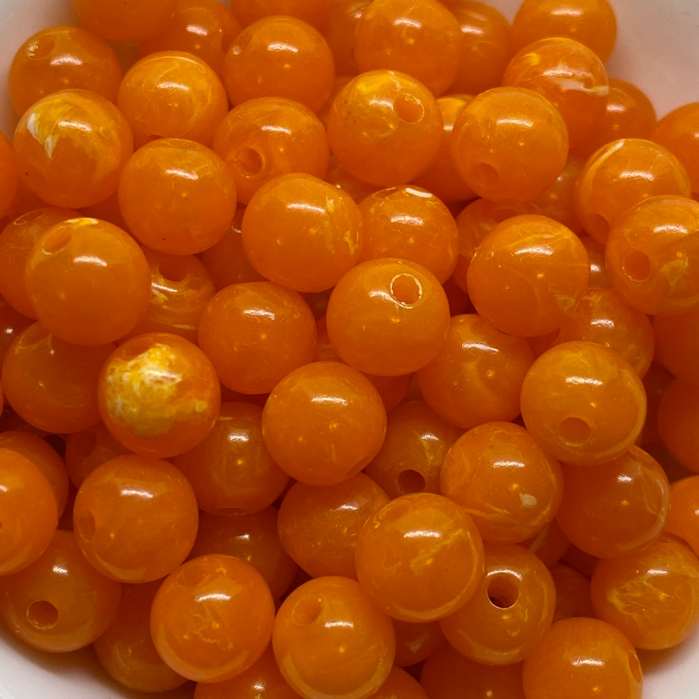 A collection of vibrant, opaque and translucent round beads with a vintage marbled effect.
