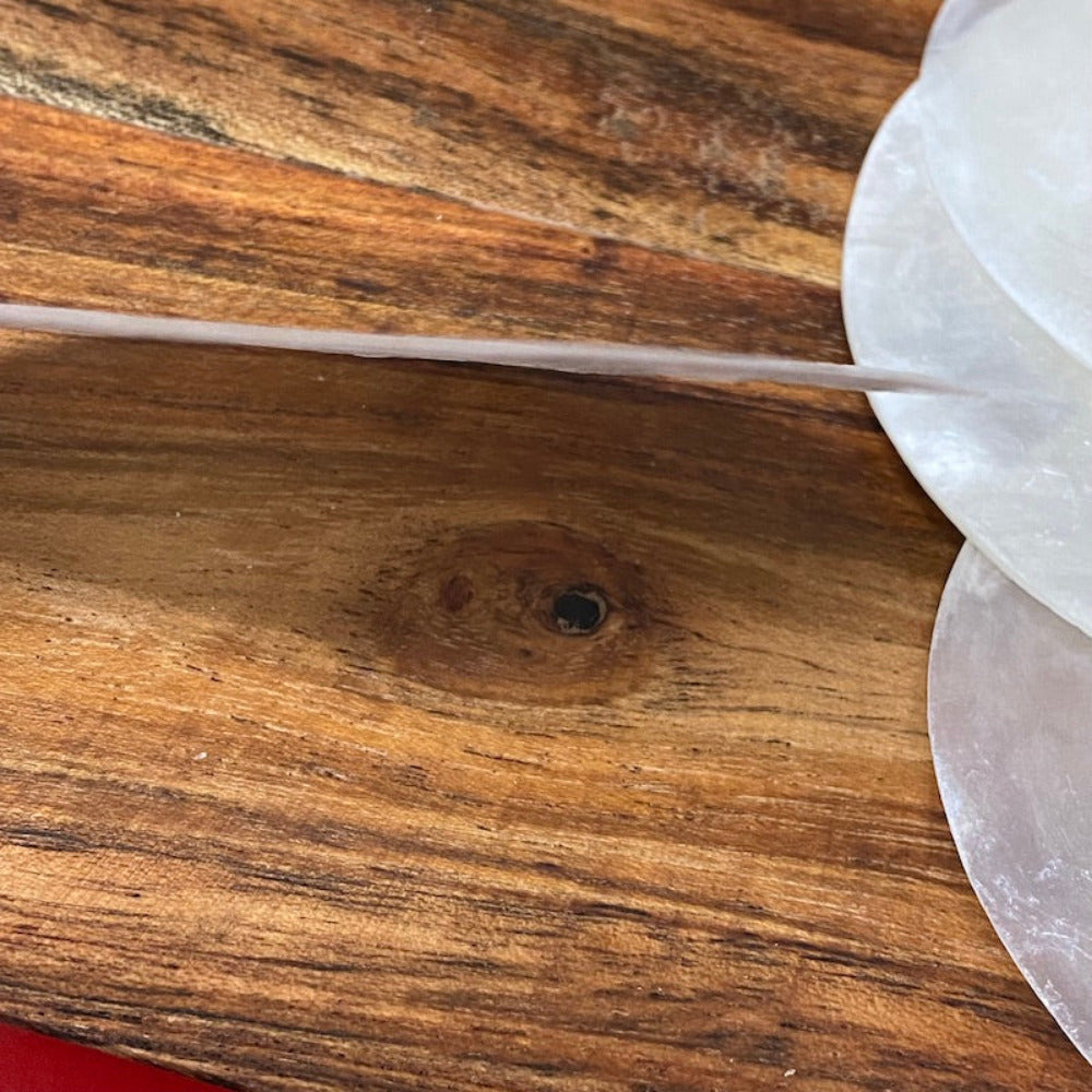 white, round capiz shell disc placed on a wooden surface used for wedding name place settings, bonbonniere, artwork and craft items displayed on a wooden surface