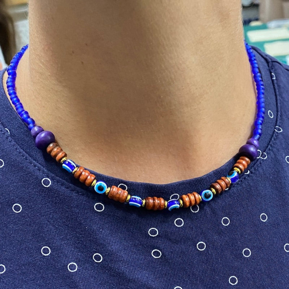 Sample of a wood and evil eye necklace in blue on a blue t-shirt to give creative ideas