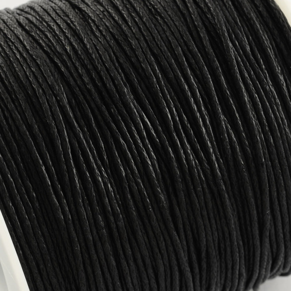 Close-up of a spool of black cord on a white background