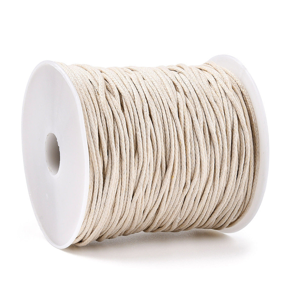Spool of beige cord on a white background