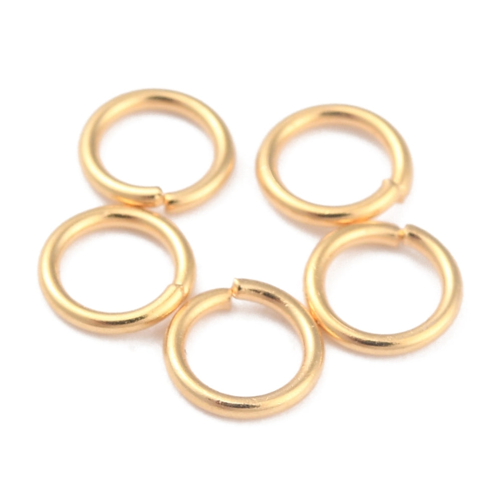 Set of gold connecting jump rings on a white background