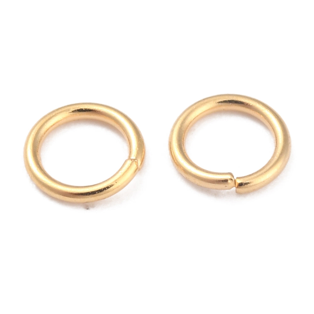 Pair of gold connecting jump rings on a white background