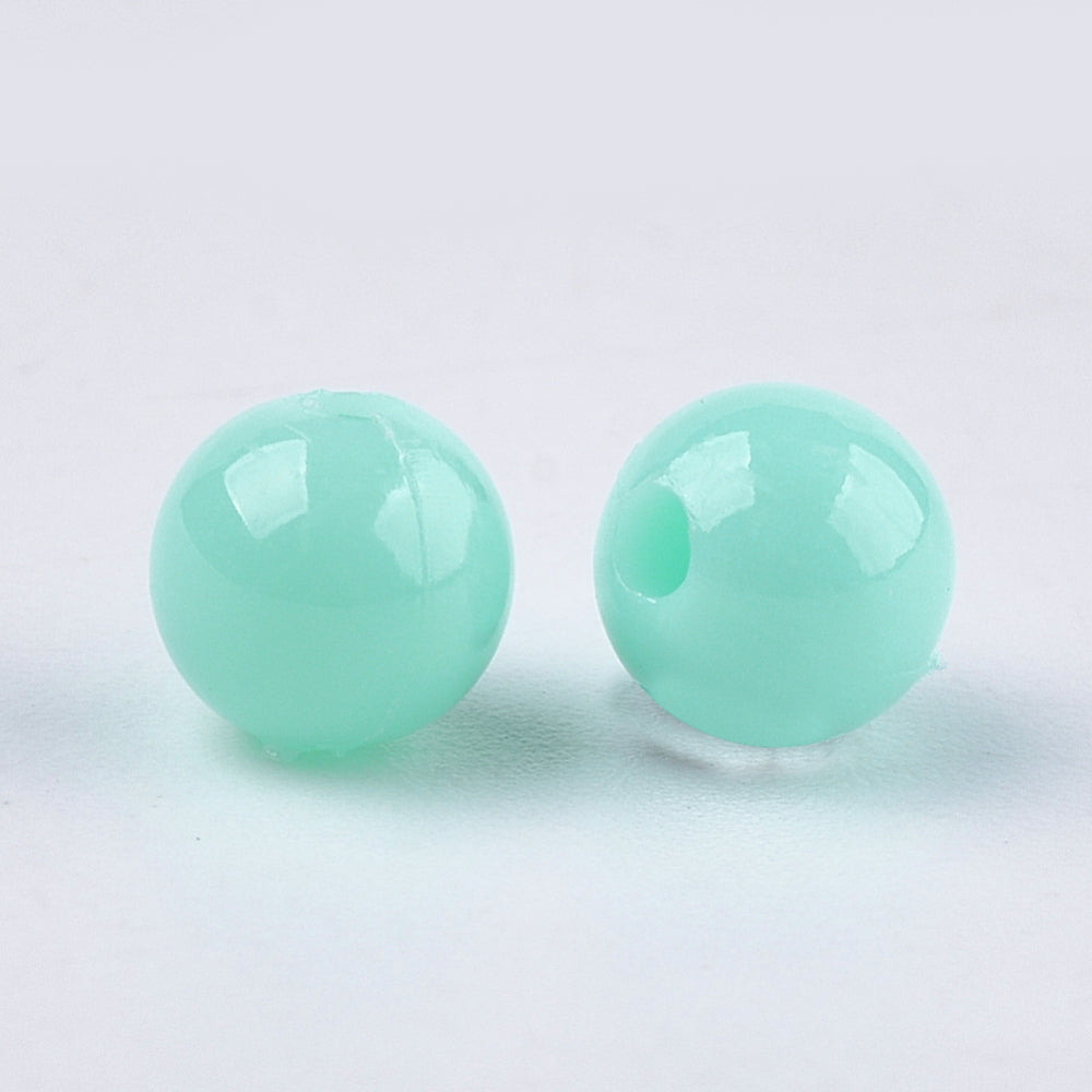 Pair of teal round beads on a white background