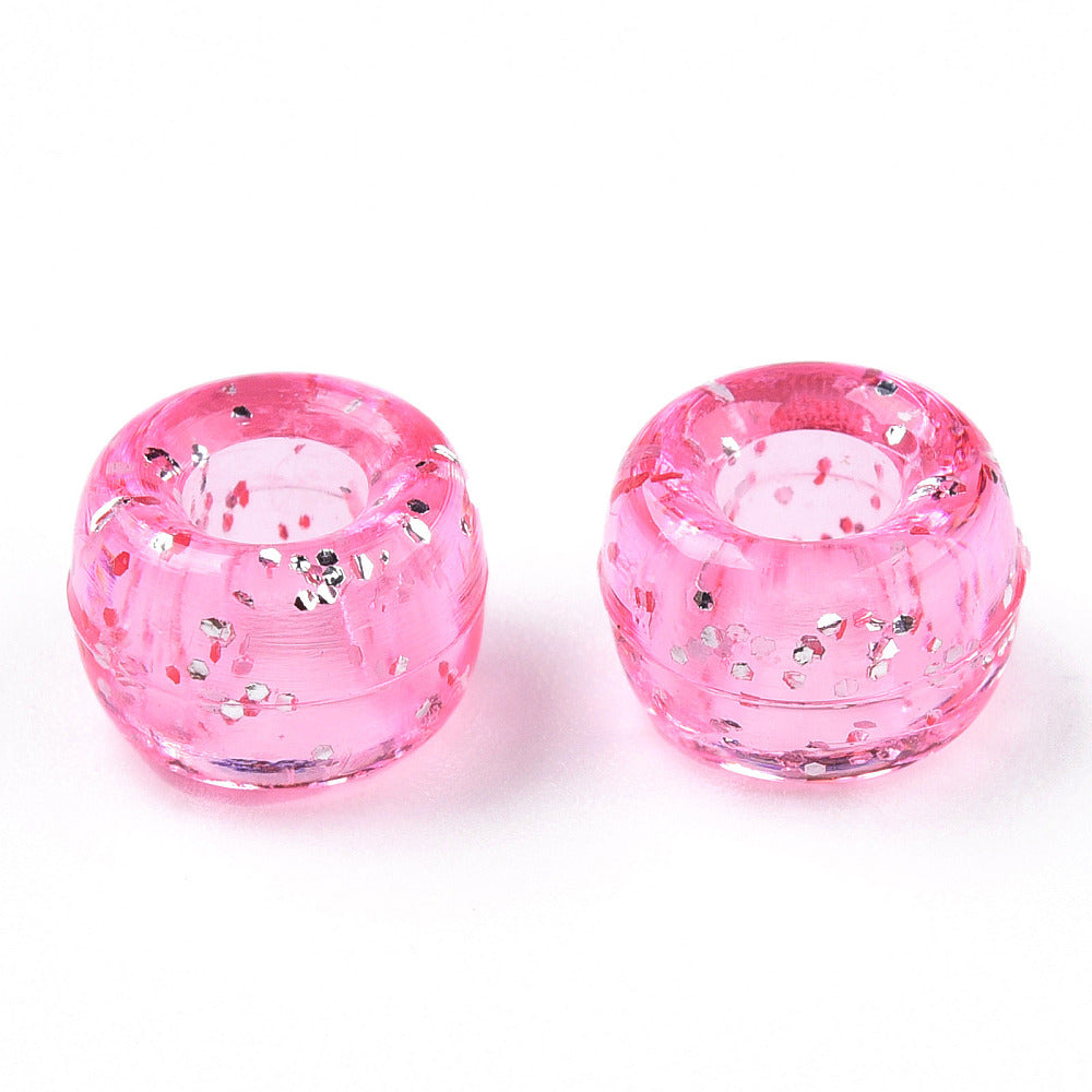 A close-up image of light pink glitter transparent acrylic pony beads with a visible hole in the center for stringing purposes.
