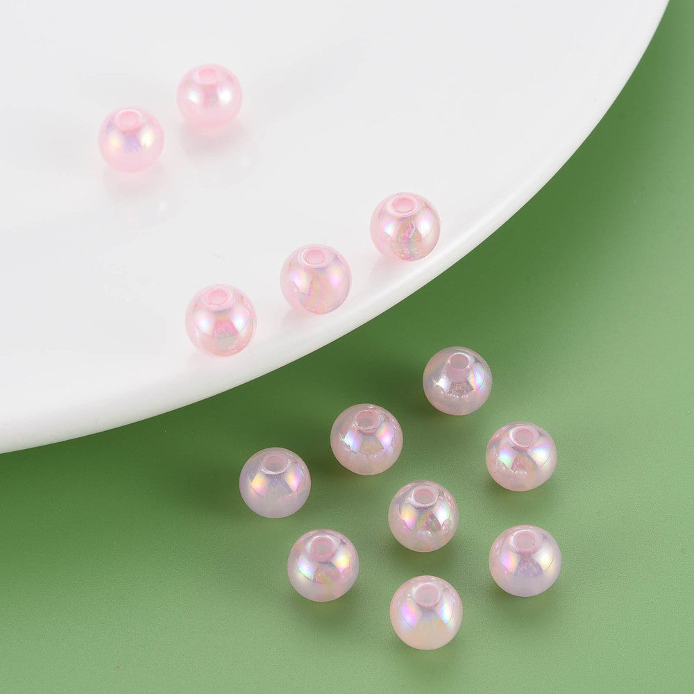 Pink pearl beads on a white plate and green background