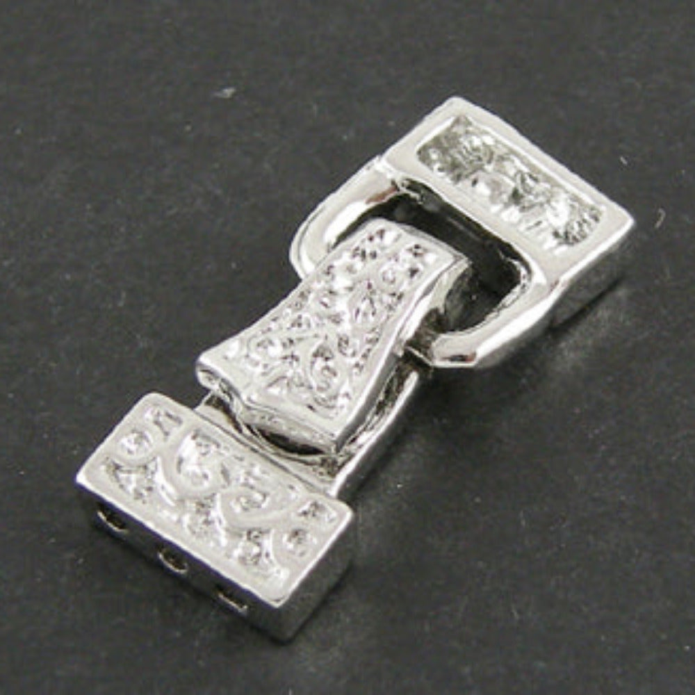 Silver magnetic fold over clasp with on a dark background