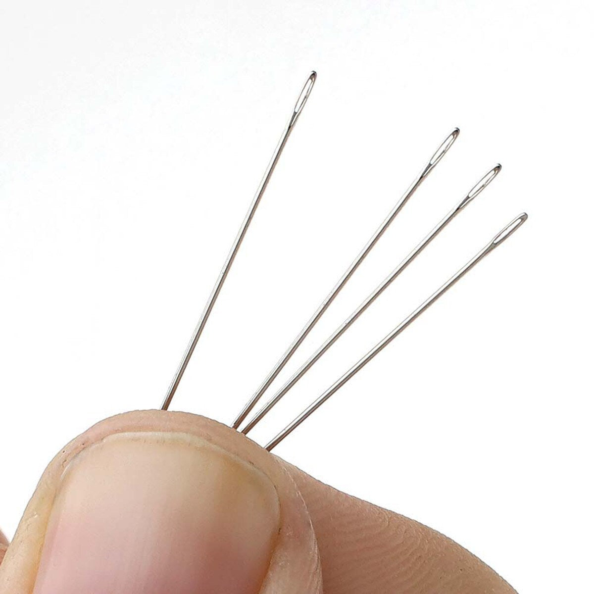 hard beading needles held with fingers on a white background showing the size of the threading holes