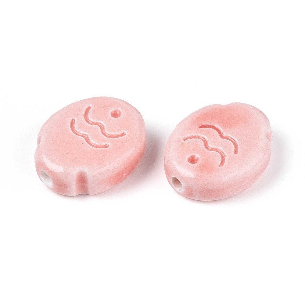 Two pink ceramic fish beads with wave designs on a white background