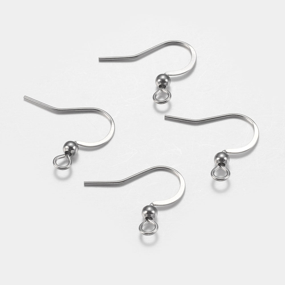 close up of a collection of silver anti tarnish ear wires with a white background and a wood ruler to show sizing