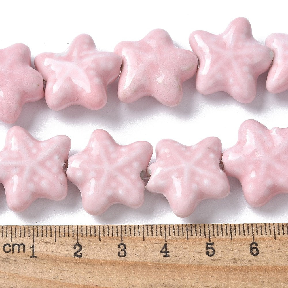 Sea themed Star-shaped pink beads with a ruler for scale on a white background