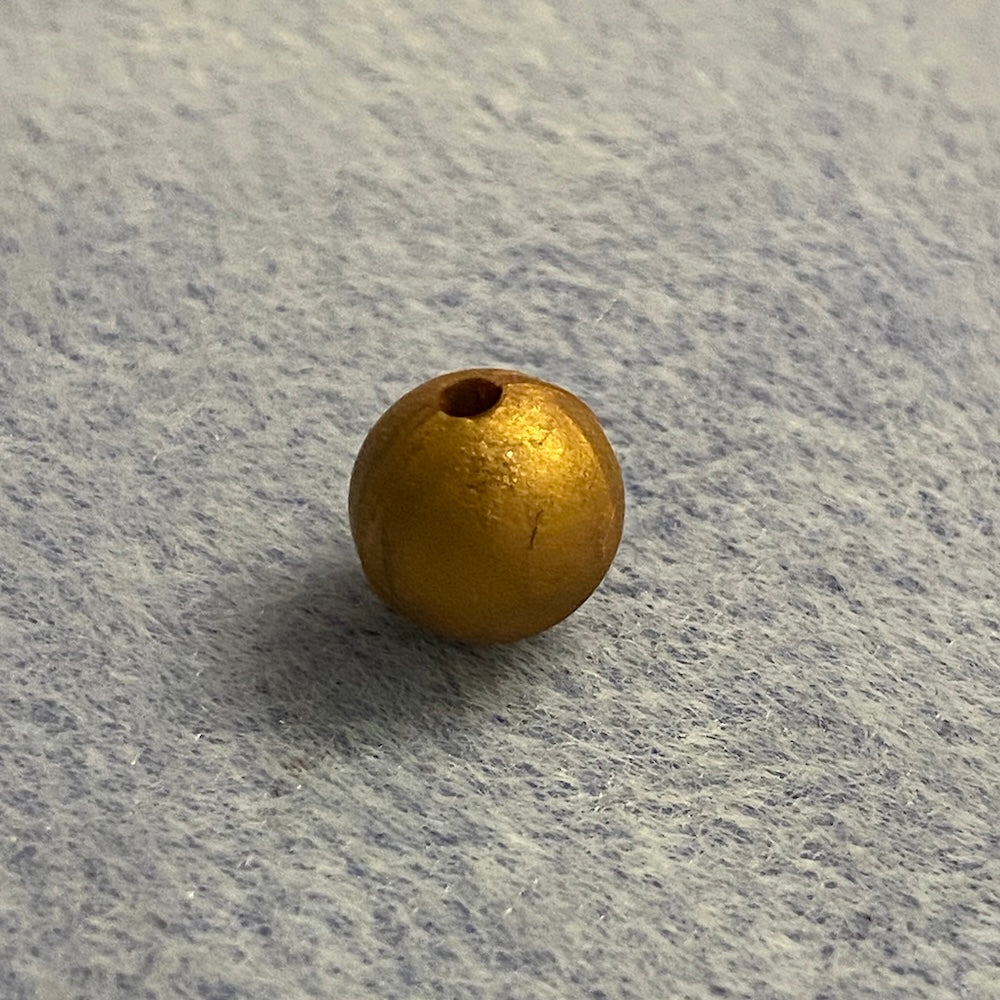 copper silicone bead on a gray textured surface