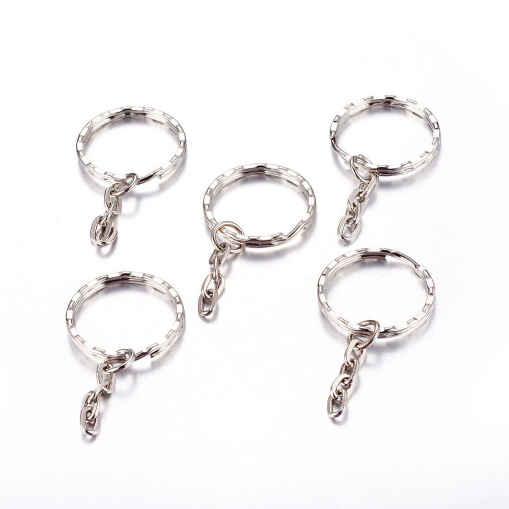 Five silver keychains with chain attachments on a white background