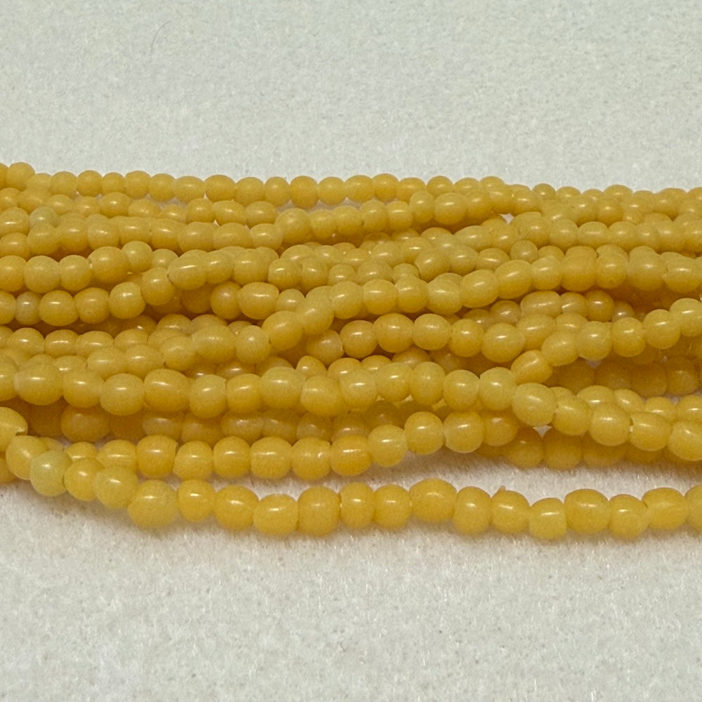 Strings of yellow round beads on a light gray background