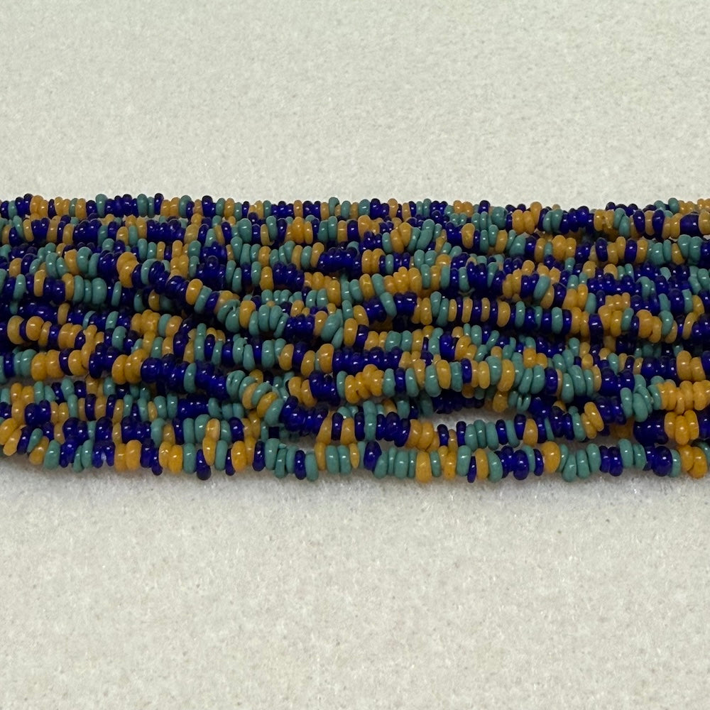 Mix Teal/Mustard/Blues color mini glass donut beads on strands on a cream background