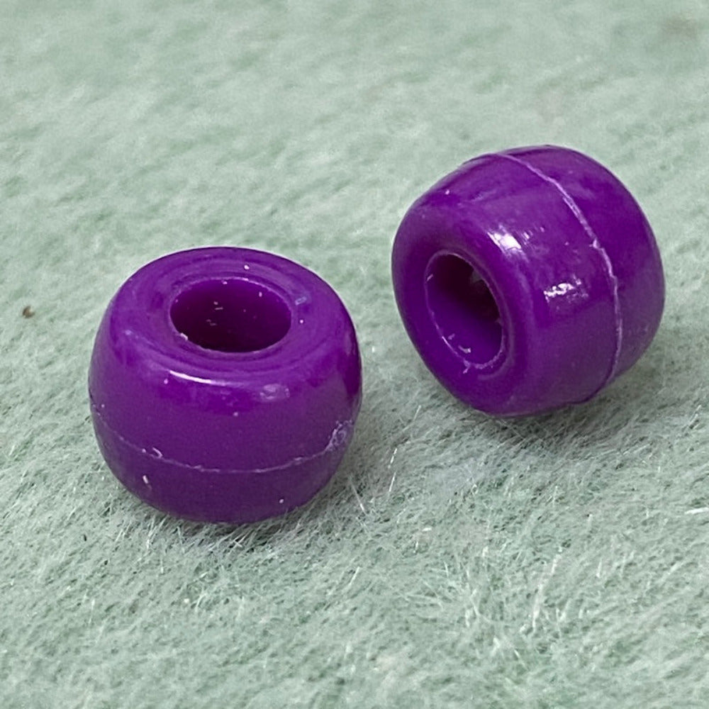 close up of 2 large holed acrylic beads used for craft and jewelry making on a white background