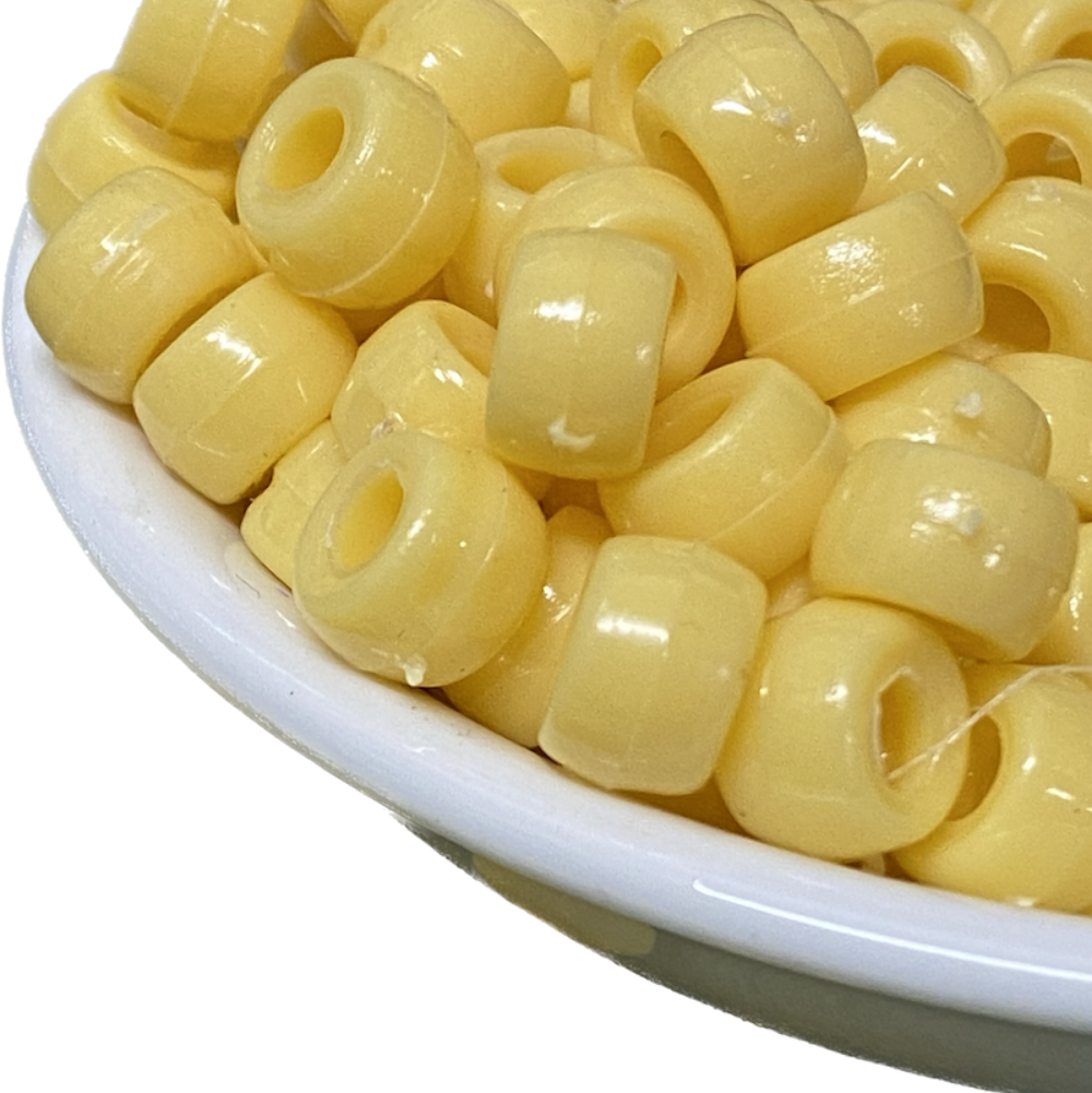 large hole plastic pony beads for the purpose of making craft and jewelry displayed in a bowl on a black surface