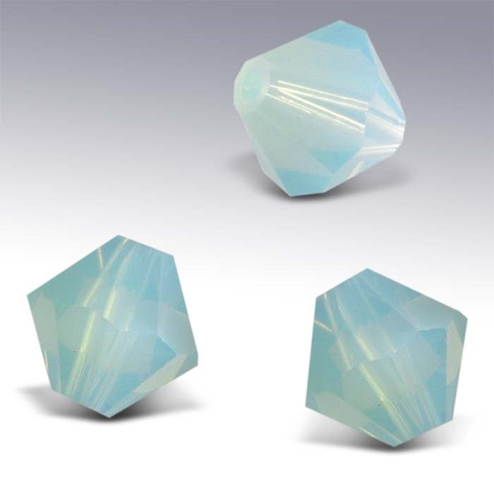 Three pale light blue faceted crystal beads on a white background