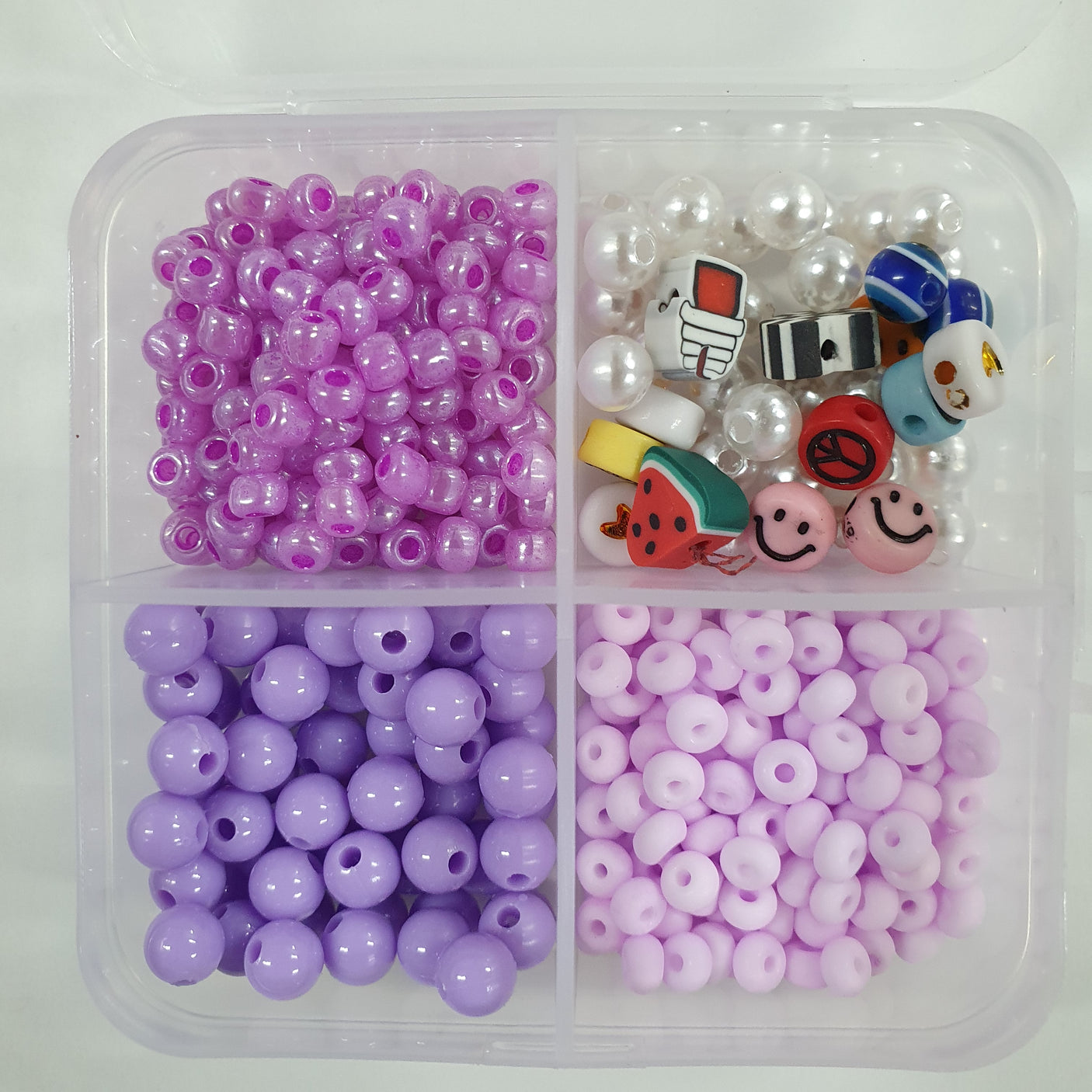 Assorted beads in a plastic container with different colors and shapes.