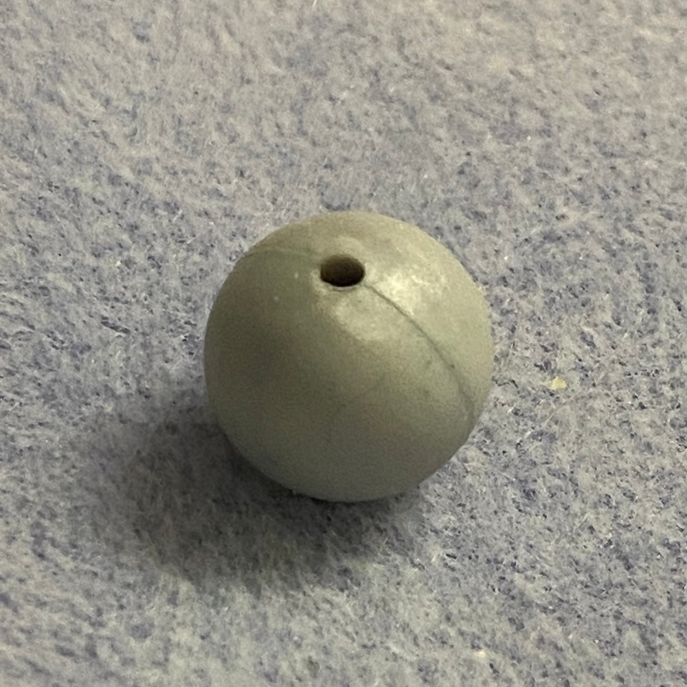 silver gray silicone bead on a gray textured surface