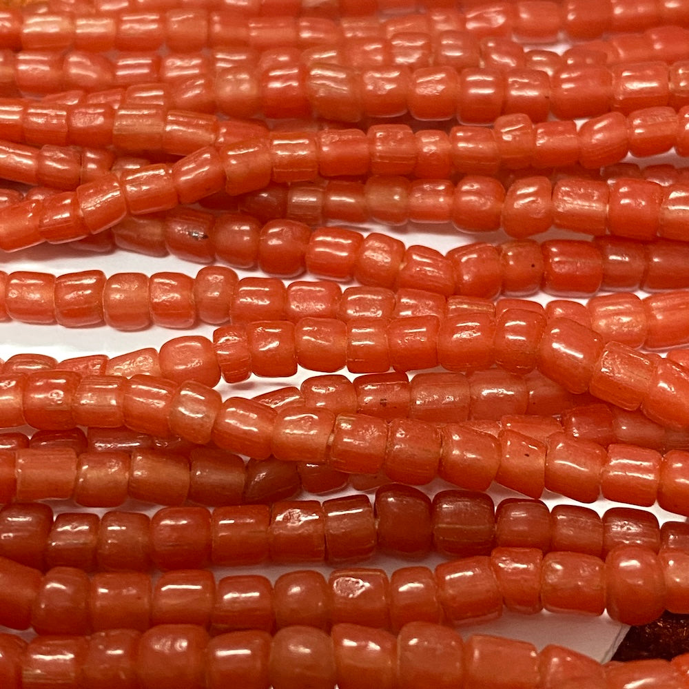 Close-up of orange tube glass beads on a white background
