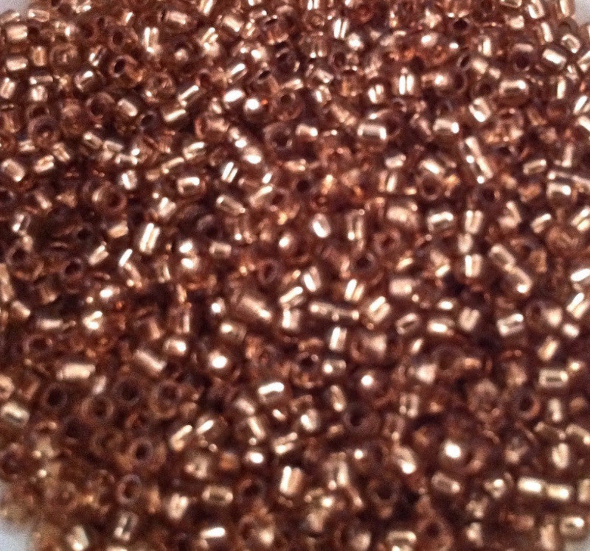 A close-up image of pewter silverlined seed beads filling the frame.