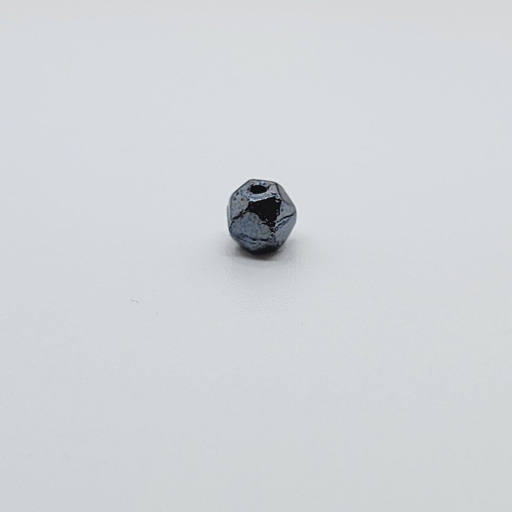 one gunmetal grey facet beads on a white background showing the threading hole