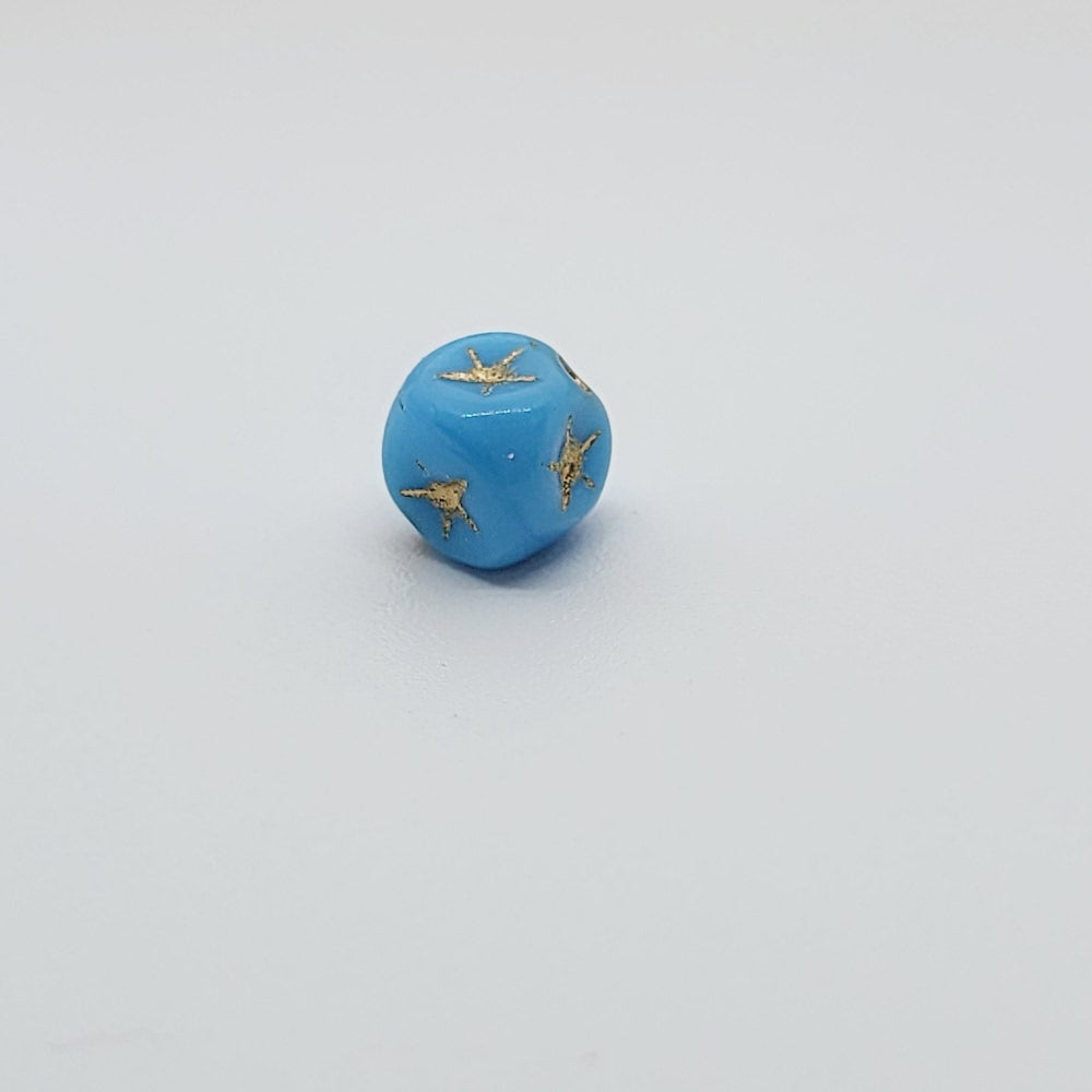 One light blue cube-shaped beadswith gold stars etching.