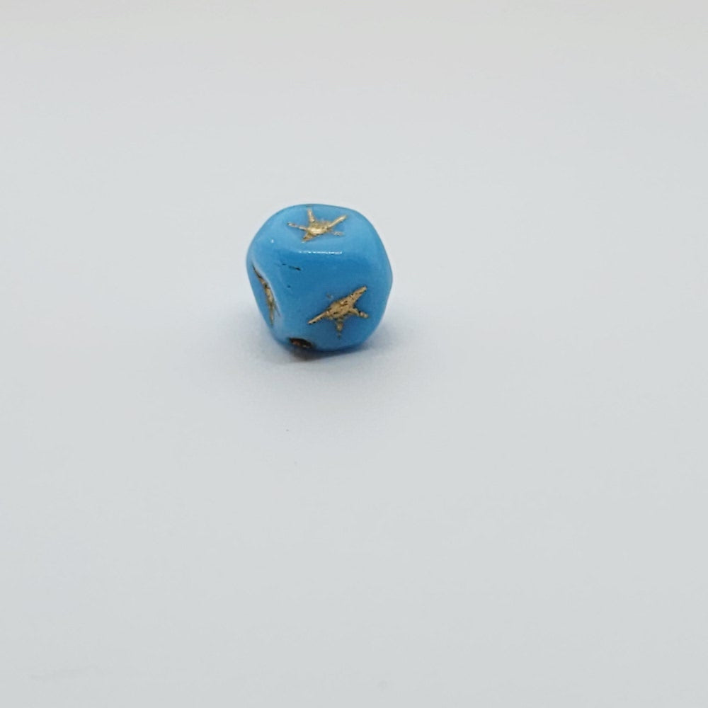 One light blue cube-shaped beadswith gold stars etching.