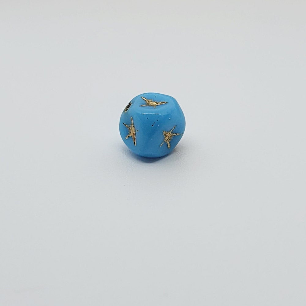 One light blue cube-shaped beadswith gold stars etching.