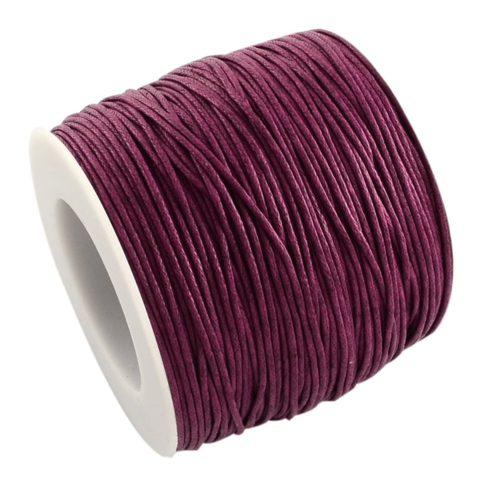 A spool of dark violet wax cotton cord used for crafting and jewelry making.