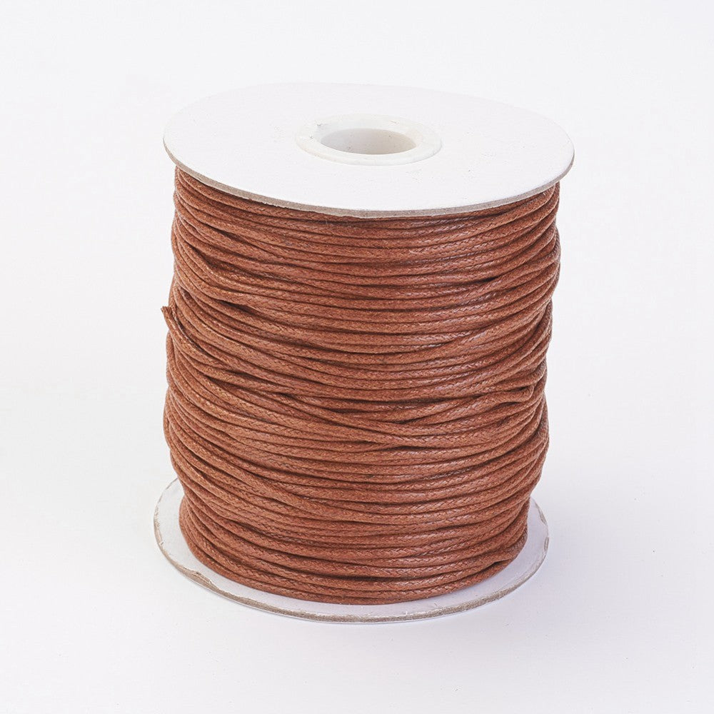 A spool of sienna colored wax cotton cord for crafting.