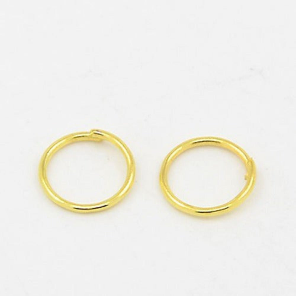 two large gold jumprings on a white surface