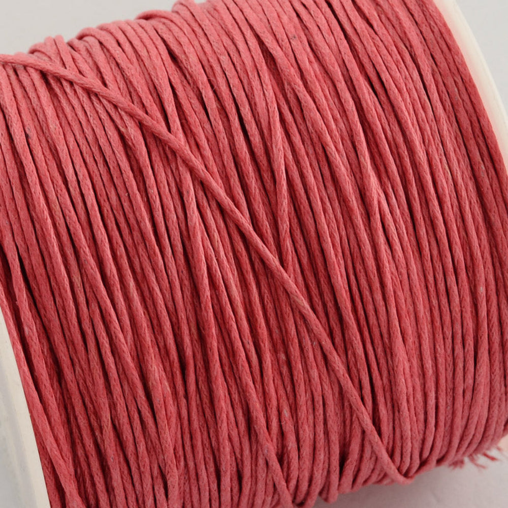 A spool of light coral wax cotton cord for crafting.
