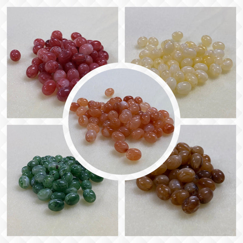 A collage of five different colours of the same gemstone look style bead in small groups on a cream background